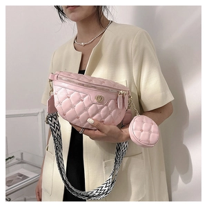 Rosafarbene Stepptasche mit breitem geometrischem Gurt und goldenem V-Logo am Model