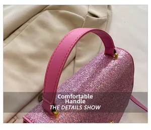 Detail of glitter handbag with comfortable pink leather handle and gold hardware