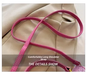 Close-up of pink crossbody shoulder strap with rhinestone details on a beige blazer
