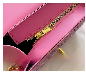 Close-up of golden metal zipper on pink leather and glitter fabric shoulder bag
