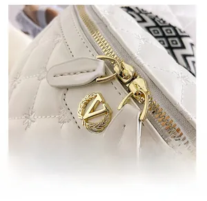 Nahaufnahme der weißen gesteppten Ledertasche mit Sternstickerei, goldenem V-Logo und Zippern