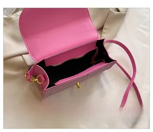 Internal view of pink handbag showing main compartment, zipper pocket and golden twist lock