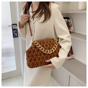 Detail of vintage brown quilted bag with chunky gold chain and leather shoulder strap