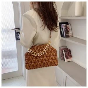 Close-up of brown quilted cloud bag with gold chain and refined diamond stitching