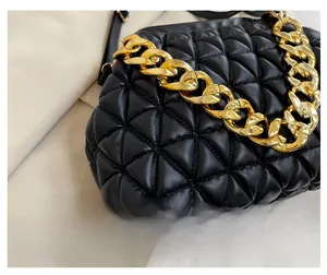 Detail of black quilted cloud bag with premium leather texture and chunky gold chain