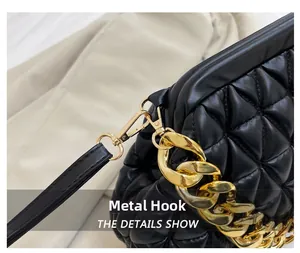 Detail of the golden hardware hook and chunky metal chain on the black quilted cloud bag