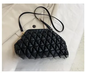 Detail of black cloud bag with triangular quilting and gold metal hardware accents