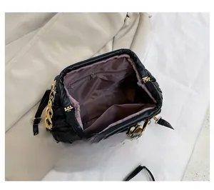 Detail view of the black quilted cloud bag showing the interior compartment and gold chain
