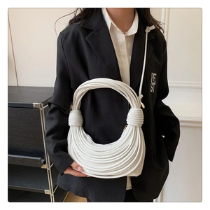 Detailed view of a white woven crescent bag with textured rope layering and knot details