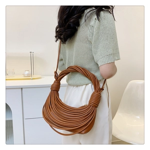Detail shot of brown woven knotted shoulder bag showing rich texture and leather finish