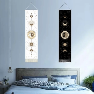 Detail of bohemian sun and moon tapestries with fringe hanging in a cozy bedroom decor