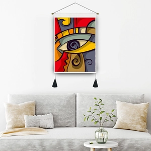 Modern abstract eye pattern tapestry with black tassels on a white living room wall