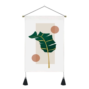Minimalist wall hanging tapestry featuring a green banana leaf design with black tassels