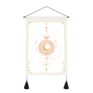 Détail d'une tapisserie nordique avec motifs soleil et lune dorés et pompons noirs