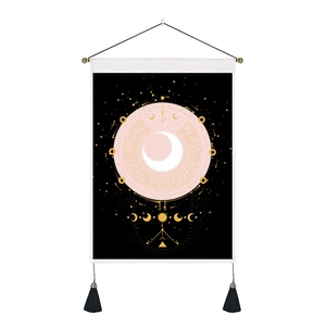 Détail d'une tapisserie nordique avec phases de lune, étoiles dorées et pompons noirs