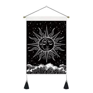 Détail de la tapisserie murale minimaliste soleil et lune avec pompons noirs bohèmes