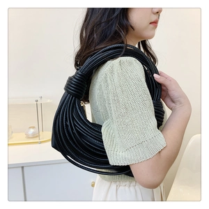 Detail view of black woven knot design shoulder bag with multi-rope texture and metal zipper