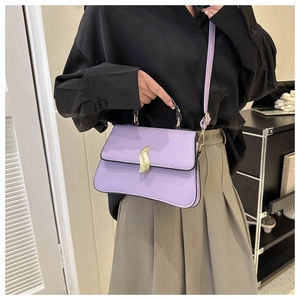 Détail du sac bandoulière lilas avec boucle dorée porté par un mannequin de côté
