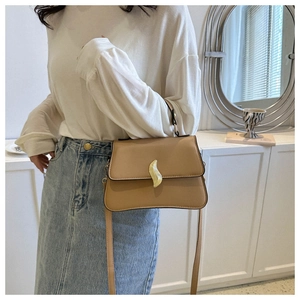 Détail du sac à bandoulière en similicuir kaki avec boucle flamme dorée et poignée ronde