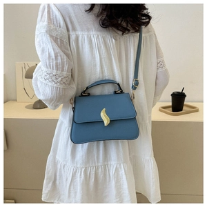 Détail du sac bandoulière en cuir bleu clair avec fermoir doré et fine lanière