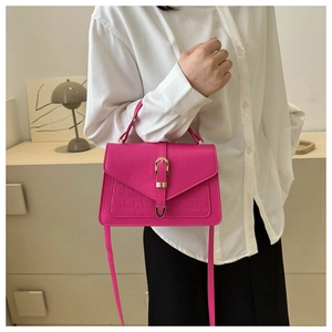 Detail of fuchsia Kelly style bag with crocodile texture and gold horseshoe clasp
