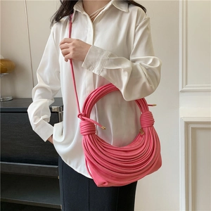 Pink woven knot crescent bag with unique rope wrap design and stylish shoulder strap