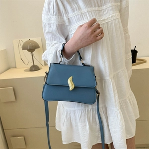 Sac à main chic en cuir bleu avec fermoir feuille doré et bandoulière réglable
