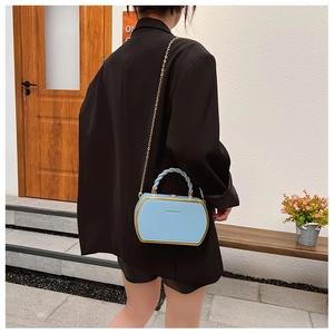 Detailansicht der hellblauen Box-Tasche mit Goldkante und spiralförmigem Griff