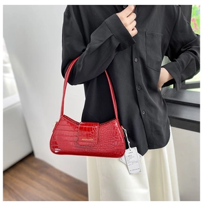 Détail du sac porté épaule en cuir verni rouge à motif crocodile et logo doré