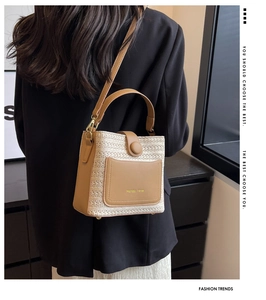 Détail du sac seau tissé avec bordure en cuir marron et logo de marque Mondan Verse