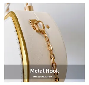 Nahaufnahme des eleganten goldenen Karabinerverschlusses und der Metallkette einer Tasche
