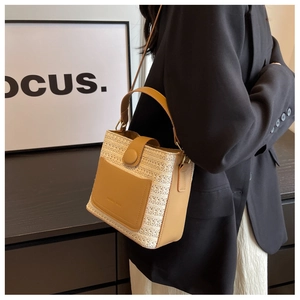 Détail du sac à main en paille tressée avec garniture en cuir marron et poignée