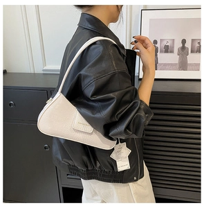 Détail d'un sac sous les aisselles en similicuir blanc crème avec motif crocodile