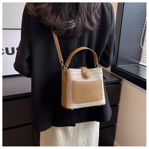 Détail du sac seau tissé contrasté avec rabat en cuir marron et boucle ronde