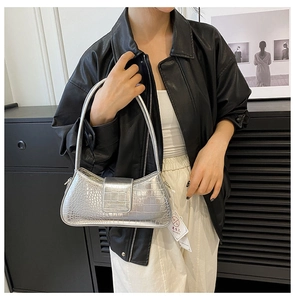 Vue détaillée de la texture crocodile argentée sur un sac baguette élégant sous le bras