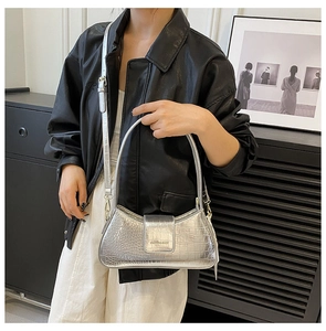 Détail du sac baguette argenté motif crocodile avec boucle métal et poignée fine