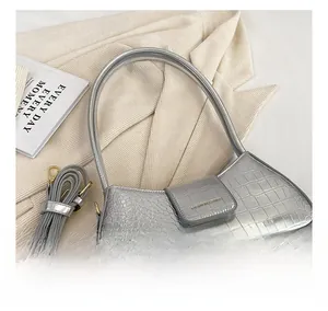 Détail du sac baguette argenté à motif crocodile avec finition métal et bandoulière