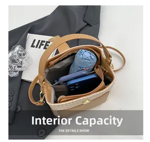 Vue détaillée de l'intérieur du sac seau tissé montrant la capacité pour téléphone et parapluie