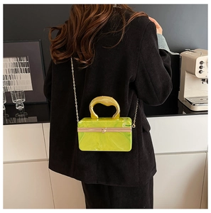Detailed view of neon green acrylic box bag with marble texture and gold handle strap