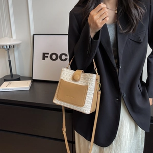 Grand sac seau tressé avec détails en cuir marron présenté dans un décor de style de vie