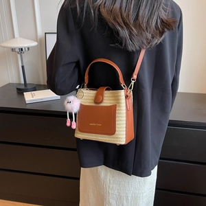 Grand sac seau en paille tressée avec bordure en cuir marron et breloque pompon rose