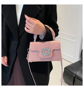 Detail of pink pleated handbag featuring a square rhinestone buckle and elegant suede texture