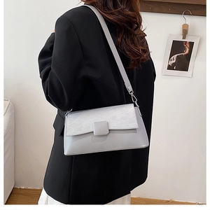 Details der hellgrauen Schultertasche mit Materialmix und quadratischer Schnalle