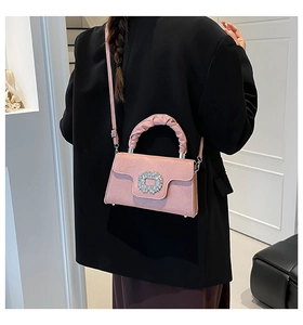 Pink pleated handbag detail with large crystal buckle and soft matte suede texture