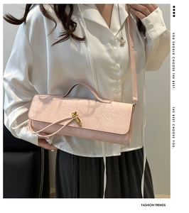 Détail du sac bandoulière rose avec motif serpent et fermoir doré chic