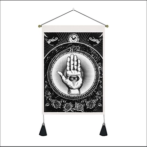 Detail of bohemian tapestry featuring Hamsa Hand and All-Seeing Eye with black tassels