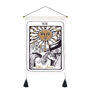 Detail of The Sun tarot tapestry with wooden hanger, black tassels and cotton linen texture