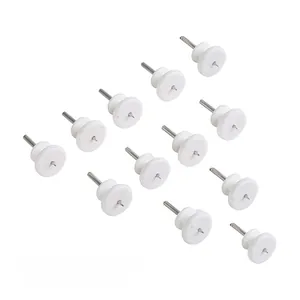 Close-up of 12 mini non-trace wall hooks with white plastic base and metal pins