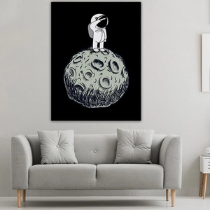 Detail of minimalist astronaut art tapestry hanging over a modern grey sofa in a living room