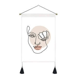 Minimalist Nordic tapestry featuring abstract female face art with pink shapes and tassels